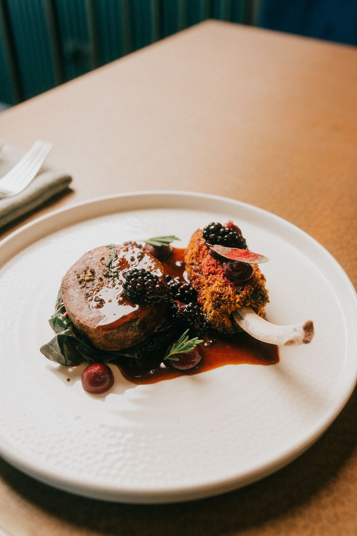 Prato de alta gastronomia servido com amoras e alecrim
