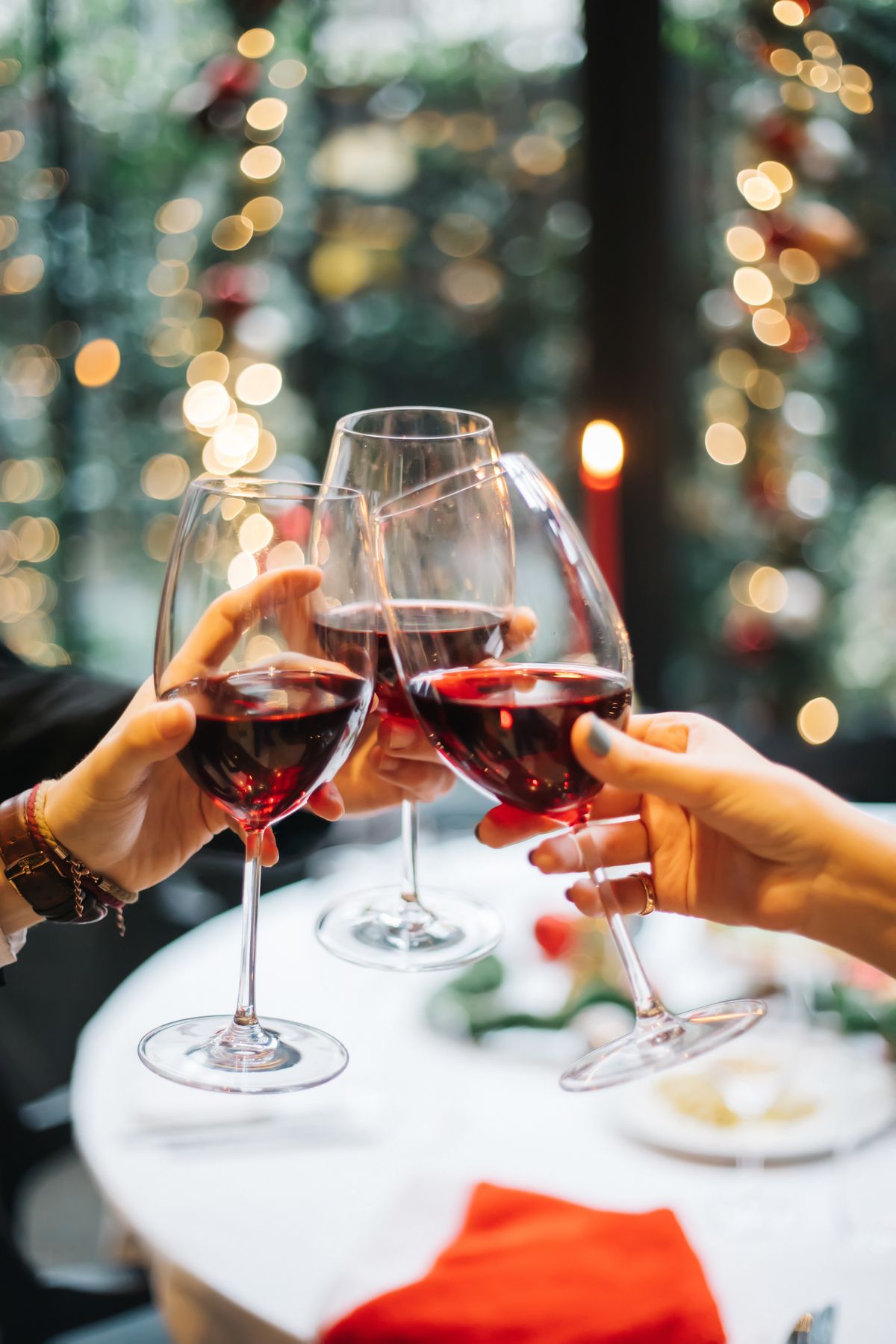 Brinde com taças de vinho tinto à mesa